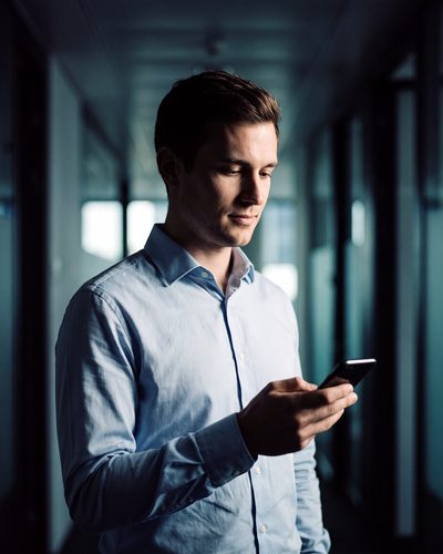 Jeune professionnel consultant une notification sécurisée CONNECTELL sur son smartphone
